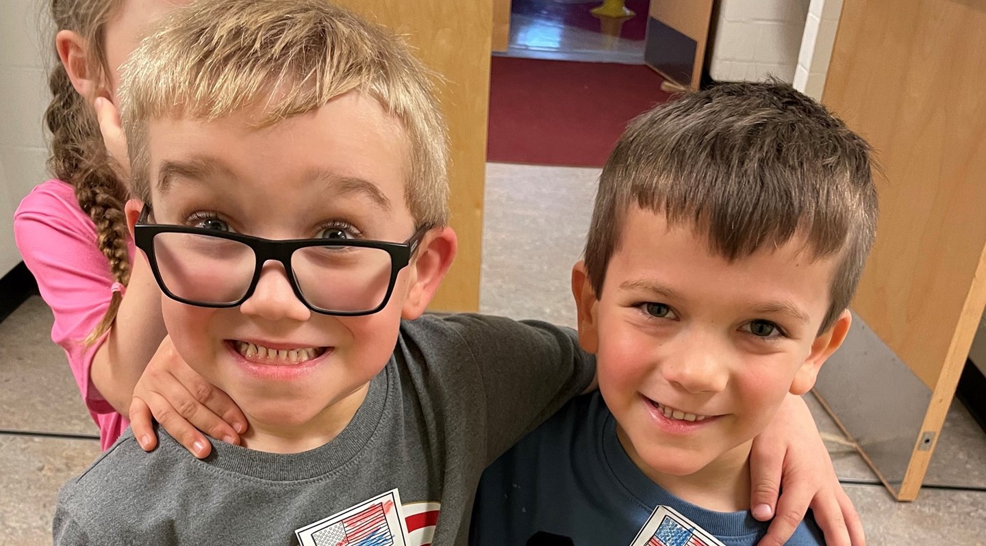 Two students one has black glasses. 