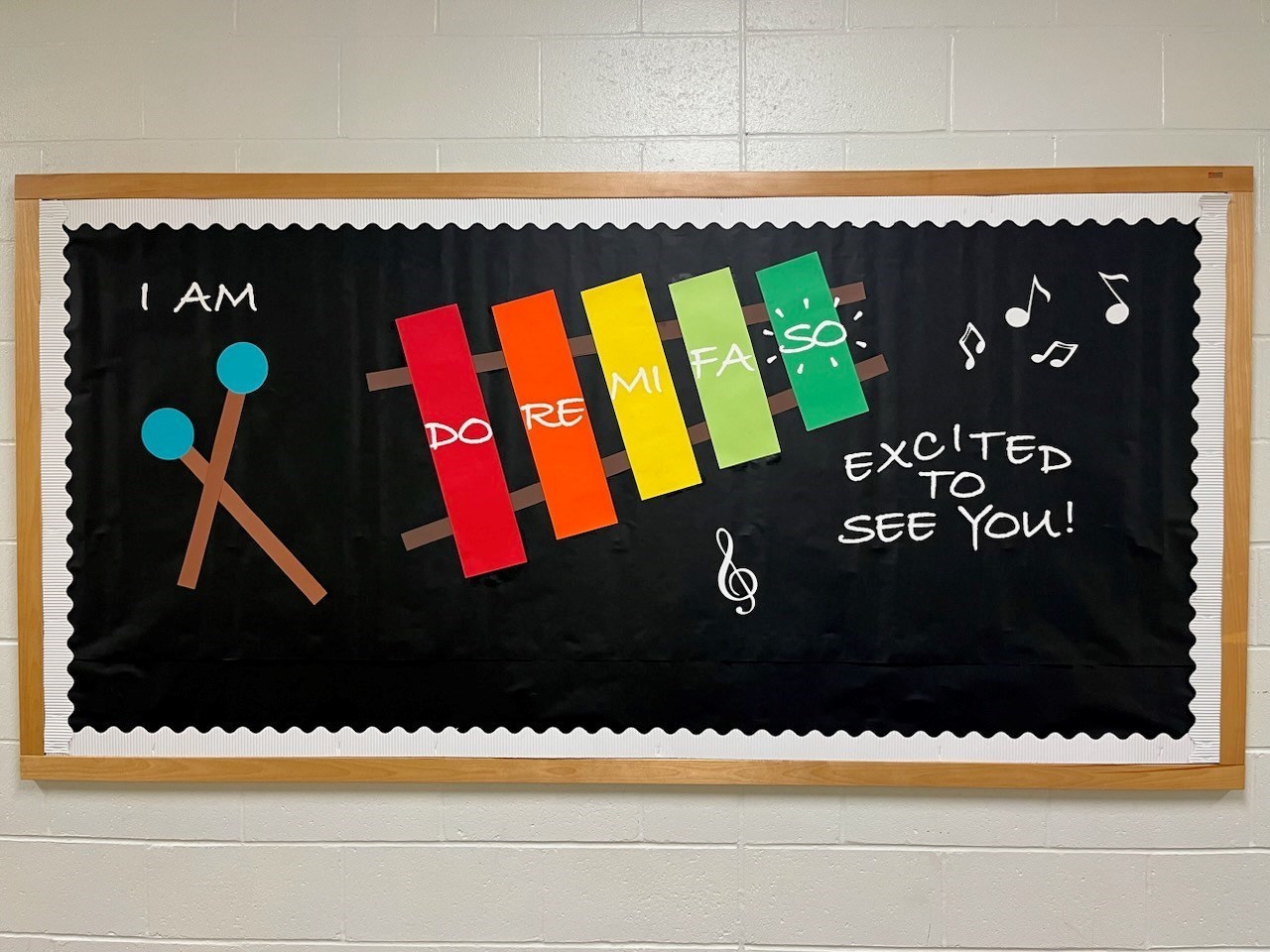 Black background with white boarder.  Drumsticks and colorful xylophone 