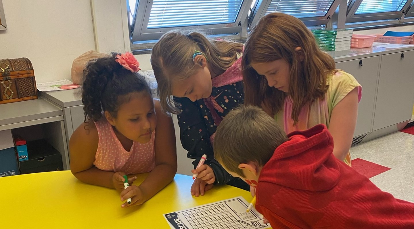 Classroom 4 students working on a white paper